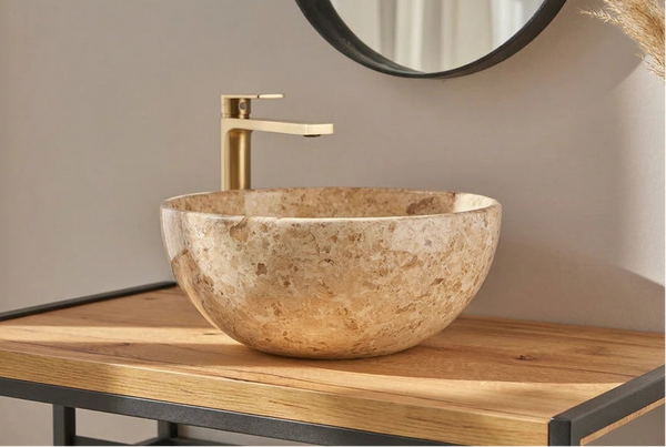 Beige gepolijste natuurstenen waskom met gouden kraan op zwart-houten frame