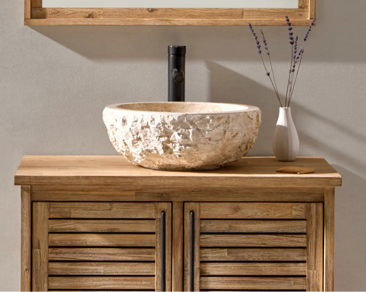 Beige natuurstenen waskom met zwarte kraan op houten badmeubel