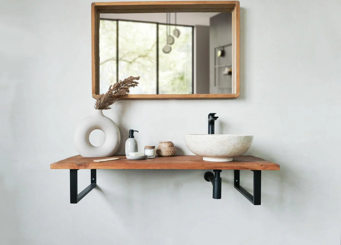 ronde beige natuurstenen waskom op wandplank met zwarte opbouwkraan in moderne badkamer