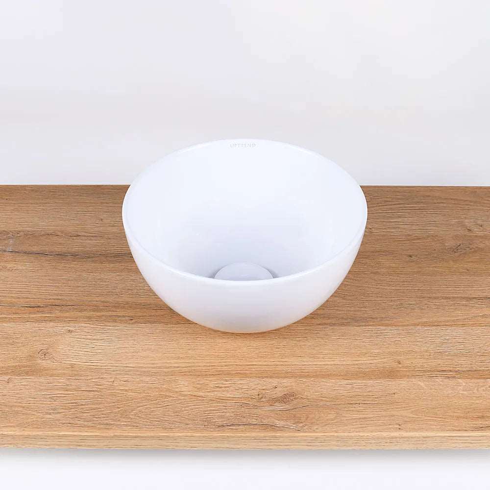Ronde witte keramische waskom 28x28x14cm op houten blad in neutrale badkamer setting, ideaal als opbouwmodel voor moderne interieurs