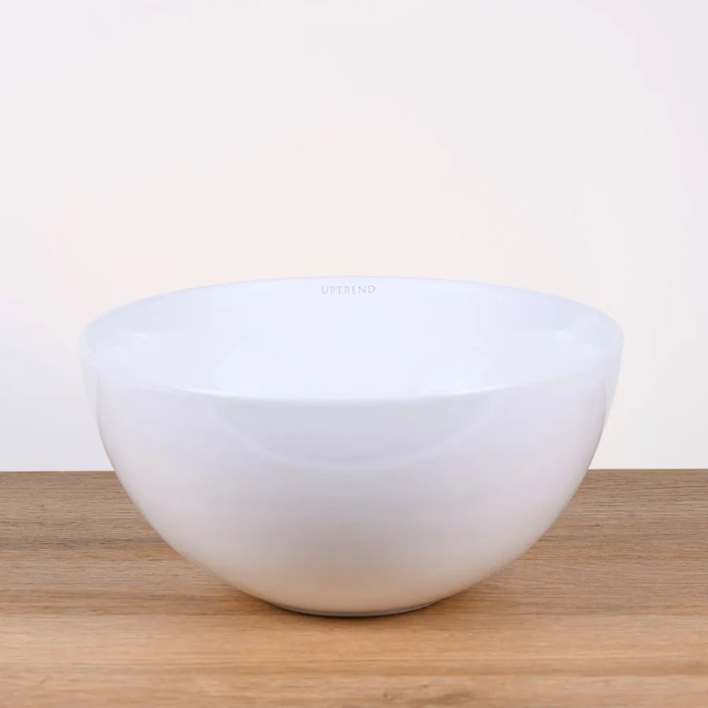 Ronde witte keramische waskom 28x28x14cm op houten blad in neutrale badkamer setting, ideaal als opbouwmodel voor moderne interieurs