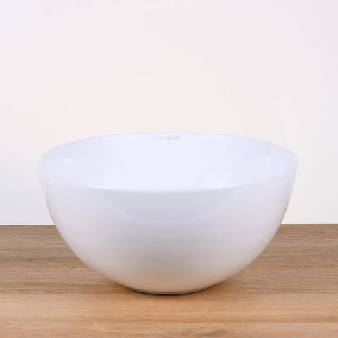 Ronde witte keramische waskom 28x28x14cm op houten blad in neutrale badkamer setting, ideaal als opbouwmodel voor moderne interieurs