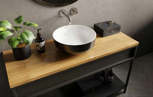 Witte opbouwwaskom 38,5x38,5x14cm met zwart patroon op houten werkblad, gecombineerd met metalen wandkraan en stijlvolle badkameraccessoires.