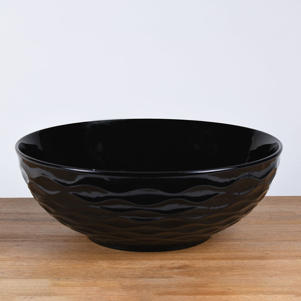 Ronde zwart keramische opbouwwaskom 42,5x42,5x14cm met subtiel golvend reliëf en gladde binnenzijde, ideaal voor een moderne en rustige badkamerstijl