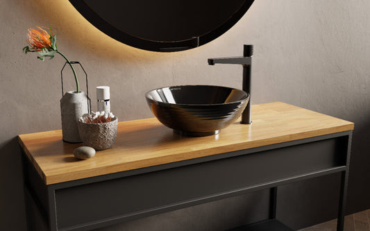 zwarte waskom met zwarte kraan op wasmeubel